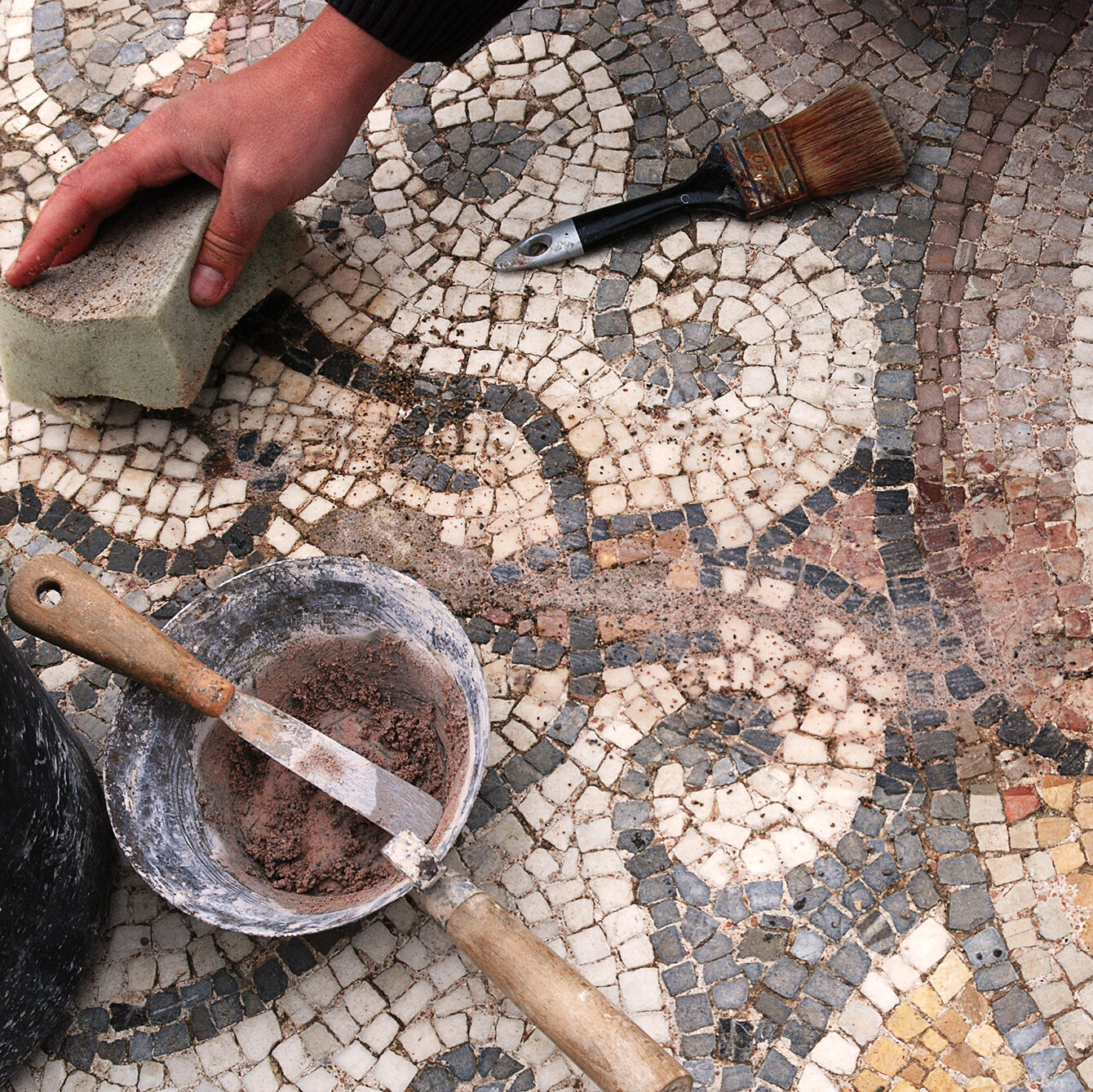 EZBld construction worker restoring flooring mosaics in a restoration project.
